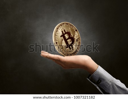 Man hands holding golden bitcoin coin on black background