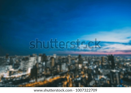 abstract blurred background of night view of city with sunset over light from building and town 