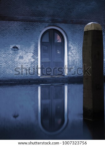 Blue lit door in a tunnel with water
