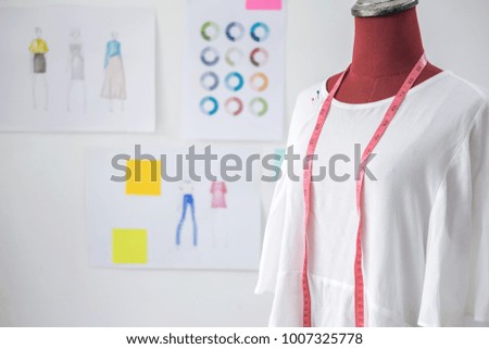 Red dummy in white clothes with measuring tape in tailors studio, Creative Design and Artistic Concept.