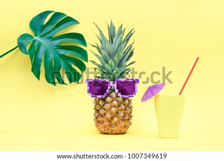 Pineapple with summer cooler cocktail on it's vacation under tropical leaf, cute summer concept, front view