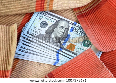 Money banknote one hundred dollars bills in the red fabric, Isolated on white background, Business finance and object concept.
