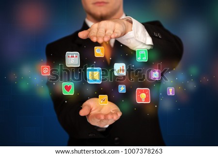 Elegant businessman holding colorful mixed media icons 