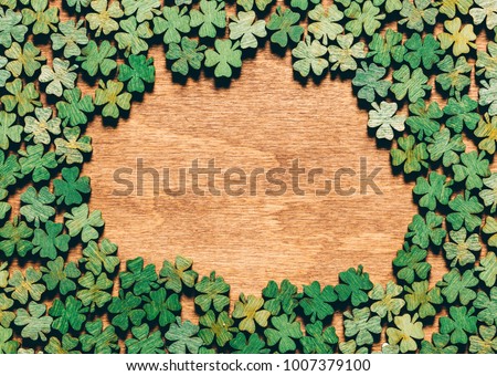 Four-leaf clovers laying on wooden floor, creating a circle. Irish culture. St. Patrick's Day. Royalty-Free Stock Photo #1007379100