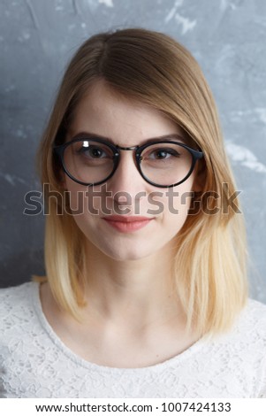 cheerful girl in glasses on a gray background, office worker
