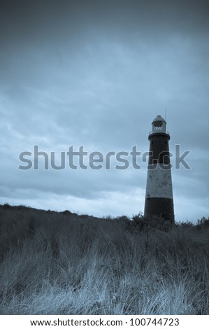 Spurn Head Lighthouse - this is a selenium toned monochrome image. The mood is gloomy and the sky is ominous in the background, providing ample space for copy if required.