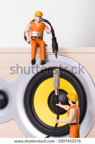 The concept of electronic equipment repair. Miniature toy engineers fixing broken wires. Close-up view.