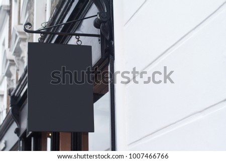 Horizontal side view of empty black square signage on a British building with classical architecture