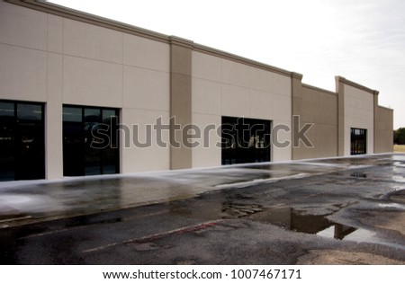 Empty strip mall with no signs and space for three shops
