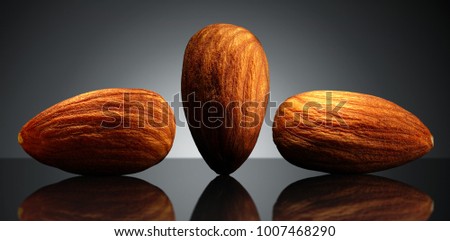Group of almond on black background with reflection. Close-up or macro. Health concept