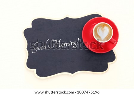 red cup of coffee with heart shape foam. Top view image