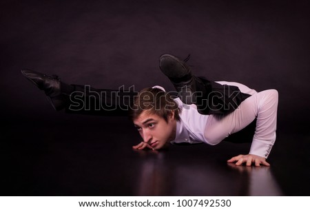 Extraordinary gymnast on a black background. The man with no bones. Studio photography of circus performers.