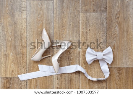 The bride's shoes and dress belt lie on the beautiful floor