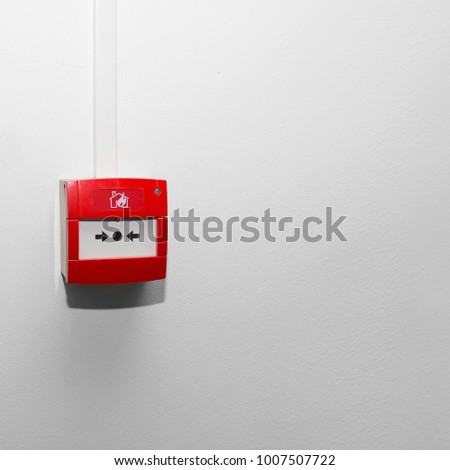 Red fire button on the white wall