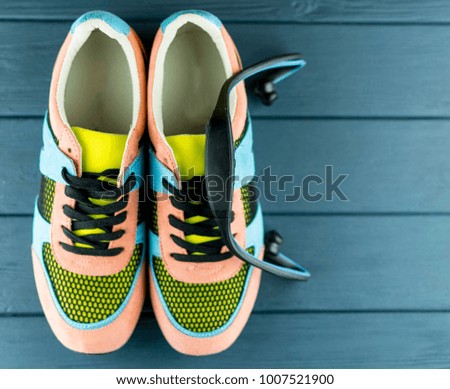 women's colorful sneakers with a headphones on a blue wooden background