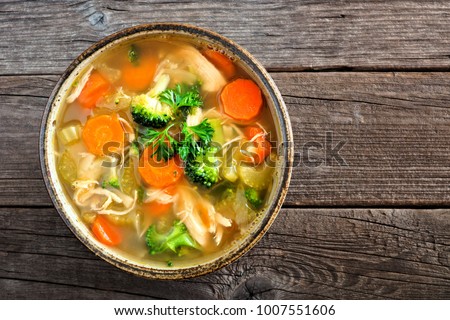 Homemade chicken vegetable soup, overhead, close up view on an old wood background Royalty-Free Stock Photo #1007551606