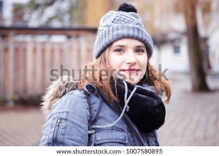portrait of beautiful young woman standing outside in the cold