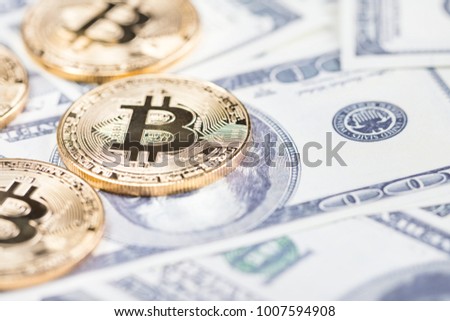 Bitcoins on dollar banknotes background, closeup 