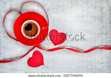 Valentine's day background. red cups with coffee, gift box decorated by red ribbon on wooden table. 8 march celebration concept. Copyspace. Top view. Vignette style.