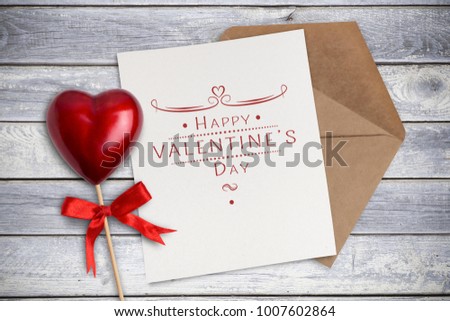 Happy Valentine's day card and a big red heart and an envelope on a wooden background
