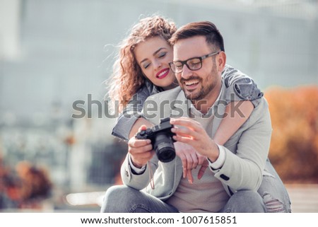 Couple of tourist having fun in the city,taking photo.