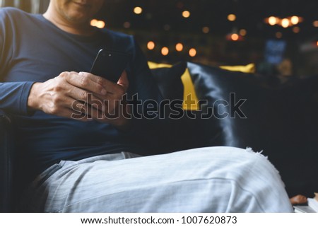 Casual asian man relaxed using mobile smart phone in cafe or night club, restaurant, close up