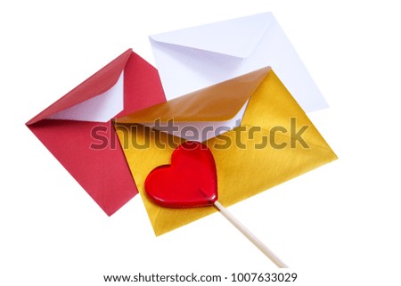 Group of open multicolored envelopes with red lollipop in the shape of a heart on the white background.