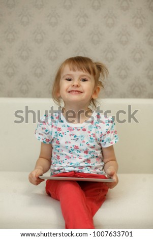 little girl watching a cartoon on a tablet