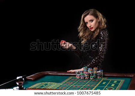 Woman playing in casino. Woman stakes piles of chips playing rou Royalty-Free Stock Photo #1007675485