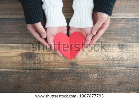 Male and female couple have a red heart on the wood table