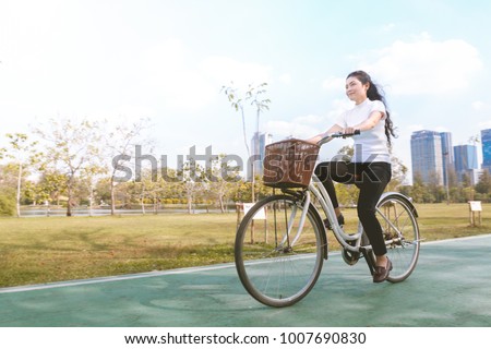 beauty asian woman in white shirt and bicycle in park Royalty-Free Stock Photo #1007690830
