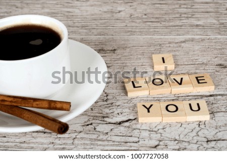 i love you letters and coffee cup with cinnamon on white wooden cafe table