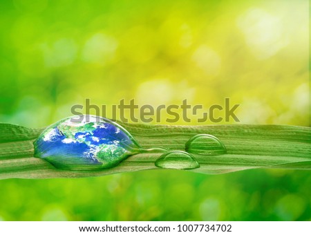 Earth in water drop reflection on green grass with soft bright nature blurred background, Earth and Environmental concept , Elements of this image furnished by NASA