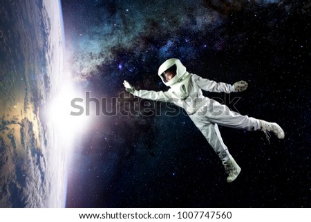 Astronaut in space, in zero gravity near the planet Earth. The concept is to find a new earth. Elements of this image furnished by NASA. Royalty-Free Stock Photo #1007747560