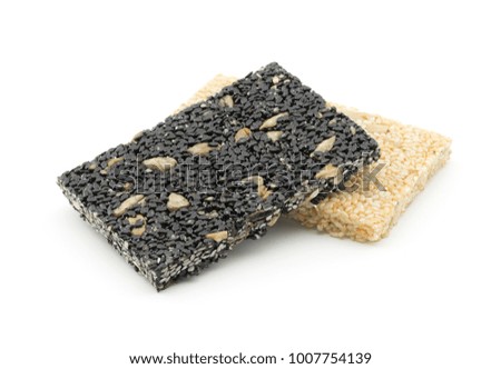 pile of sesame seeds with sunflower kernels bar on a white background