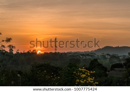 Sunset behind a mountain in an orange sky