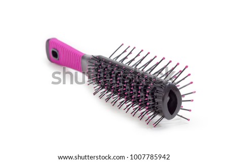 Black and pink vented hairbrush with plastic bristles and balls at their ends closeup at shallow depth of field on a white background

