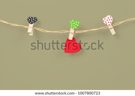 Handmade wood hearts hanging on cloth line or rope with 

trend color background.clipping path.