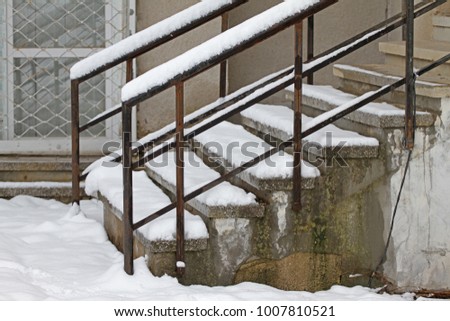 Winter. Stairs. People walk on a very snowy stairs. Uncleaned icy stairs in front the buildings, slippery stairs