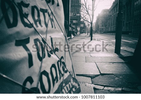 Black and White "Death Toll Soars" newspaper headline on an empty street Royalty-Free Stock Photo #1007811103