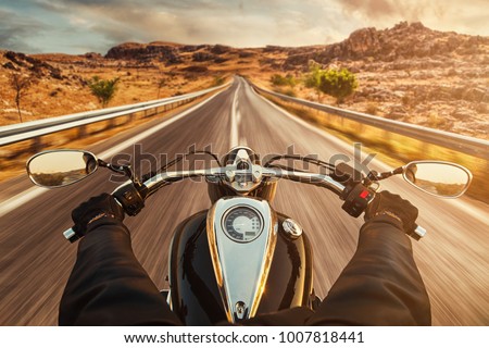 Driver riding motorcycle on an empty asphalt road Royalty-Free Stock Photo #1007818441