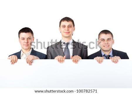 Three young businessmen hold up a large blank sign isolated on white background