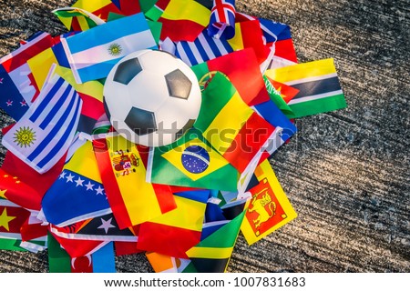 Above view of leather soccer ball on the ground with international team flags of the participating country in the championship tournament.Football equipment to play competitive game.World cup,Top-down Royalty-Free Stock Photo #1007831683