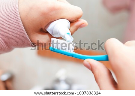 hands with toothpaste and toothbrush Royalty-Free Stock Photo #1007836324