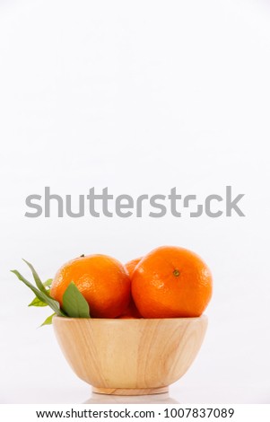 the golden orange is placed in a wooden container on the table and white background take pictures using stodio lights sport focus close up