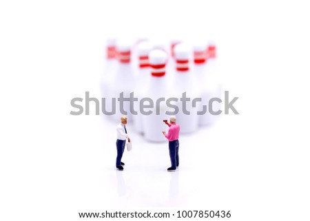 Miniature people : businessman stand with Group of Bowling Pins,business and sport concept.