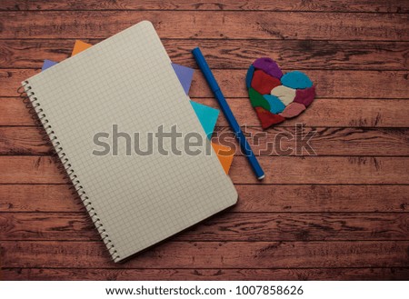 A colorful heart as a symbol of autism awareness on wooden background with text space.