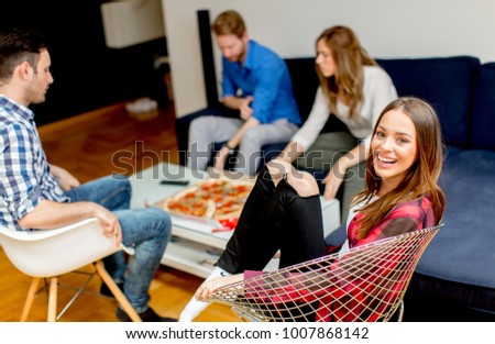 Group of young friends eating pizza at home