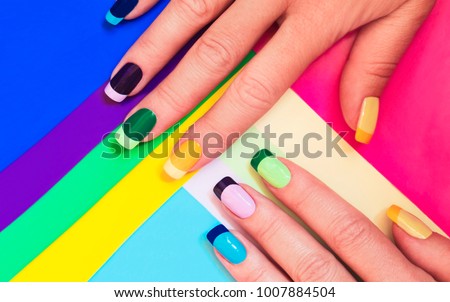 Multi-colored pastel manicure combined tone on tone with a striped background.Nail art. Royalty-Free Stock Photo #1007884504