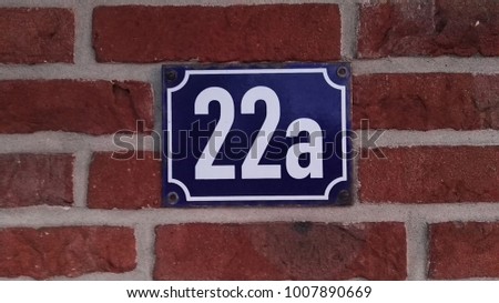 metallic house number at a clinker wall